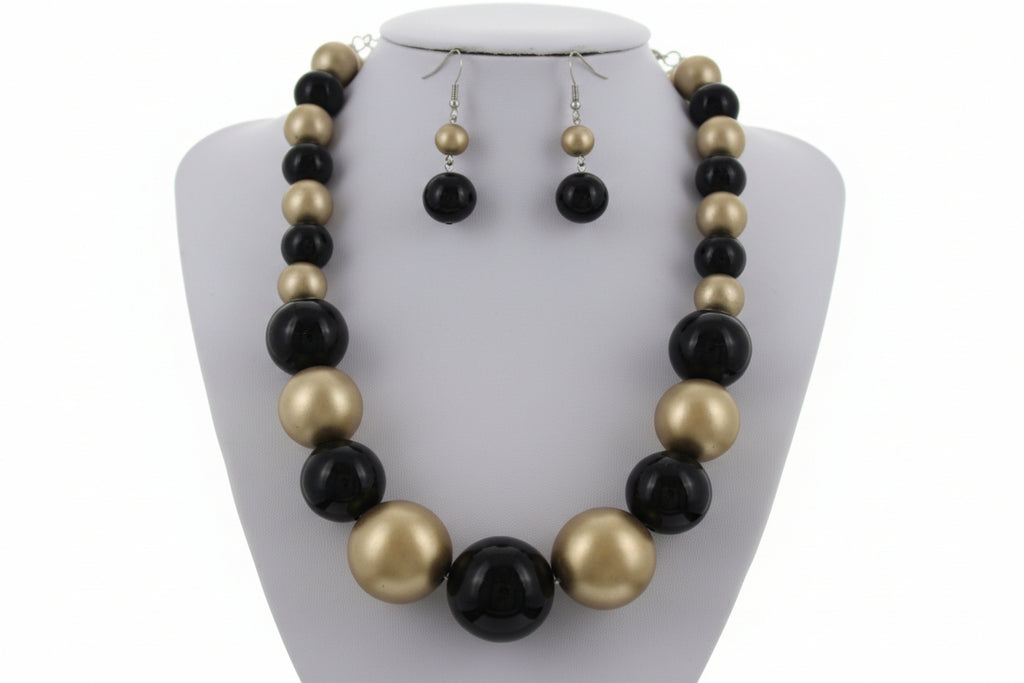 Black and gold necklace set with matching earrings on a white background