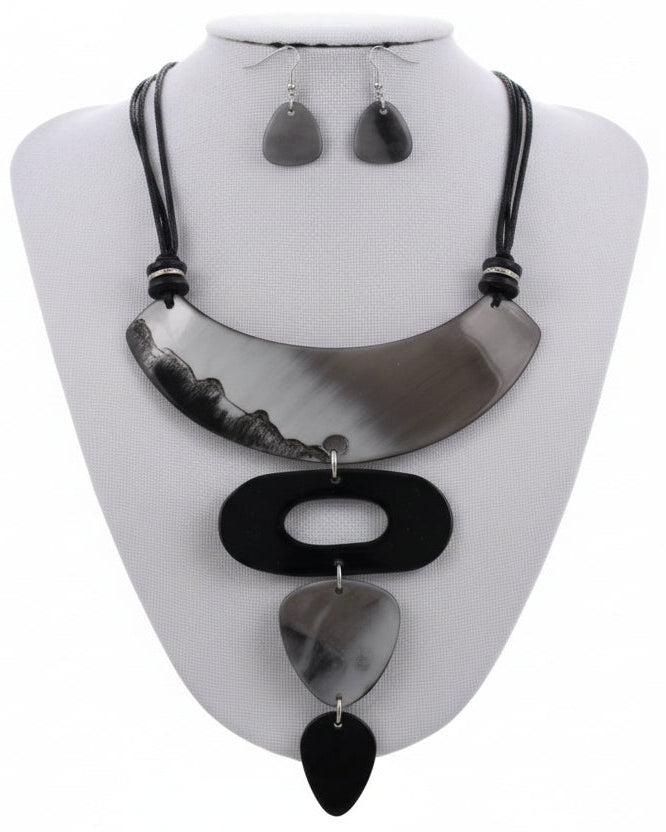 Necklace with black and white feathers on a gray background