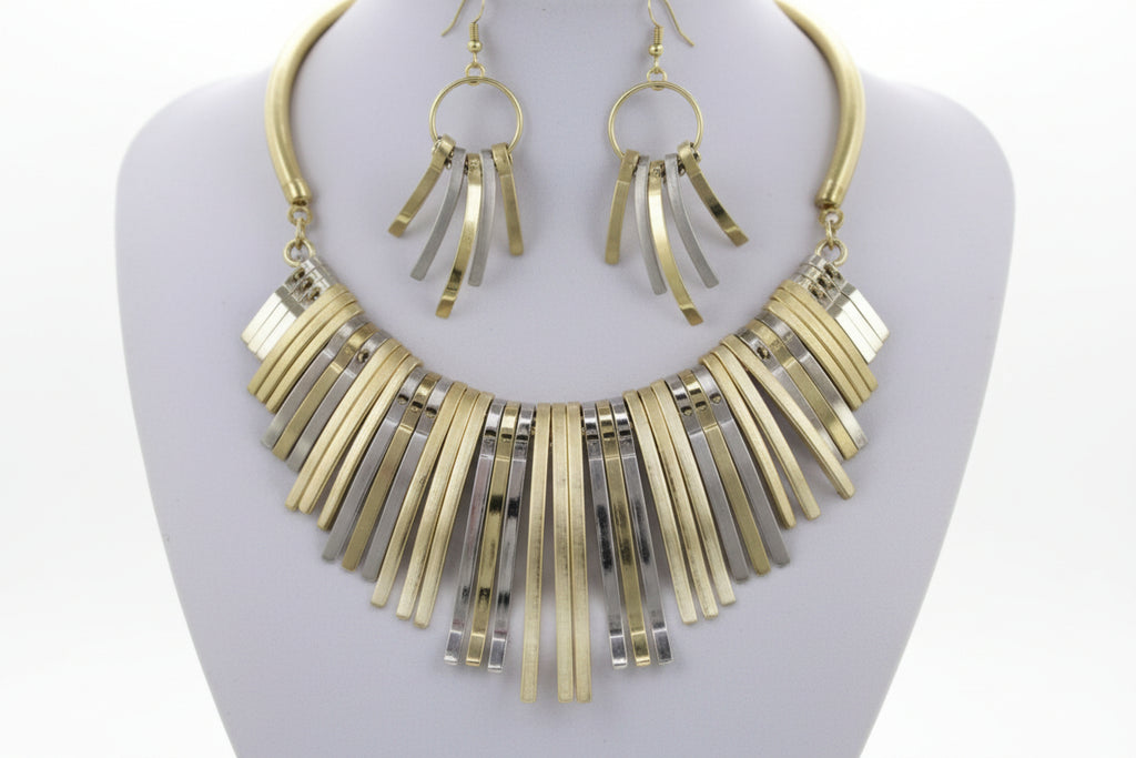 Gold necklace and earrings set on a plain background