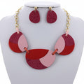 Red and gold necklace with matching earrings on a white background