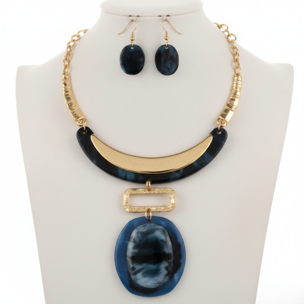 Necklace and earrings set with blue pendant on a gold chain