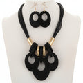 Black necklace and earrings set on a white background