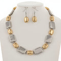 Gold and silver necklace and earrings on a white background