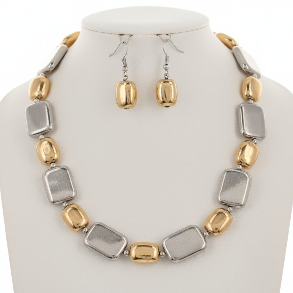 Gold and silver necklace and earrings on a white background