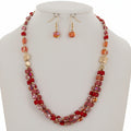 Necklace and earrings set with red and gold beads on a white background
