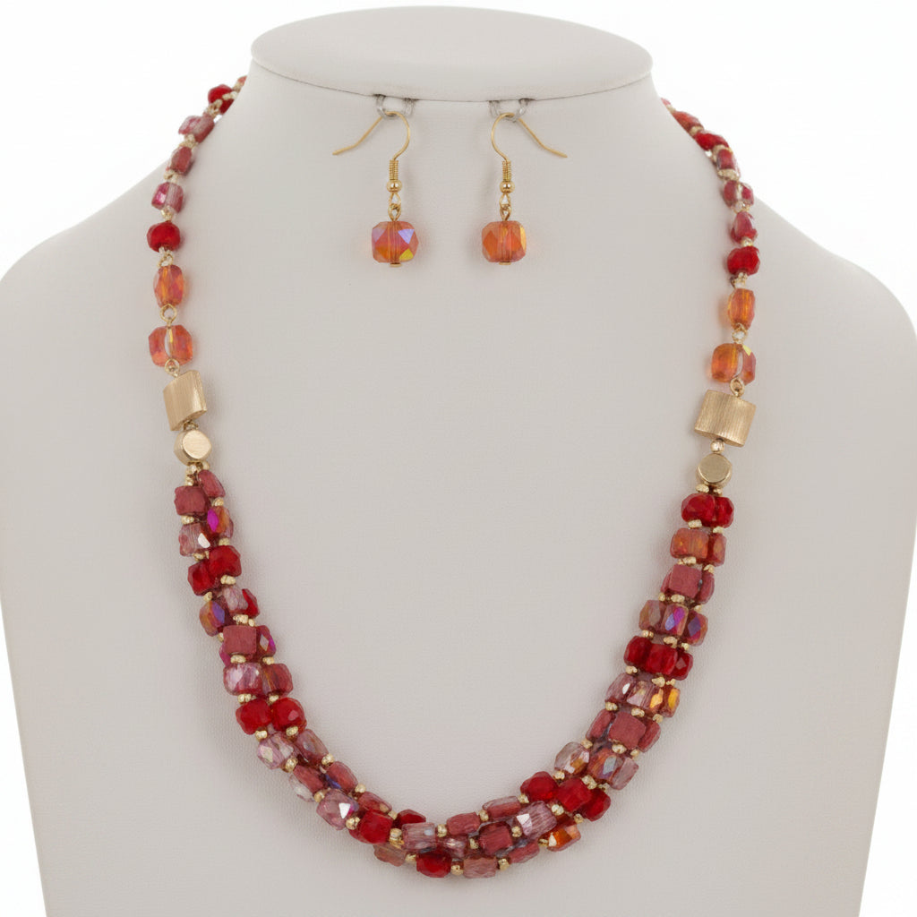 Necklace and earrings set with red and gold beads on a white background