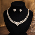 Jewelry set with necklace and earrings on a black stand against a blurred background