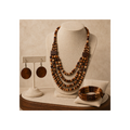 A multi-strand wooden bead necklace displayed on a beige jewelry bust, with matching wooden disc earrings on a separate stand and a matching wooden beaded bracelet on a cushion, all set against a warm beige background.