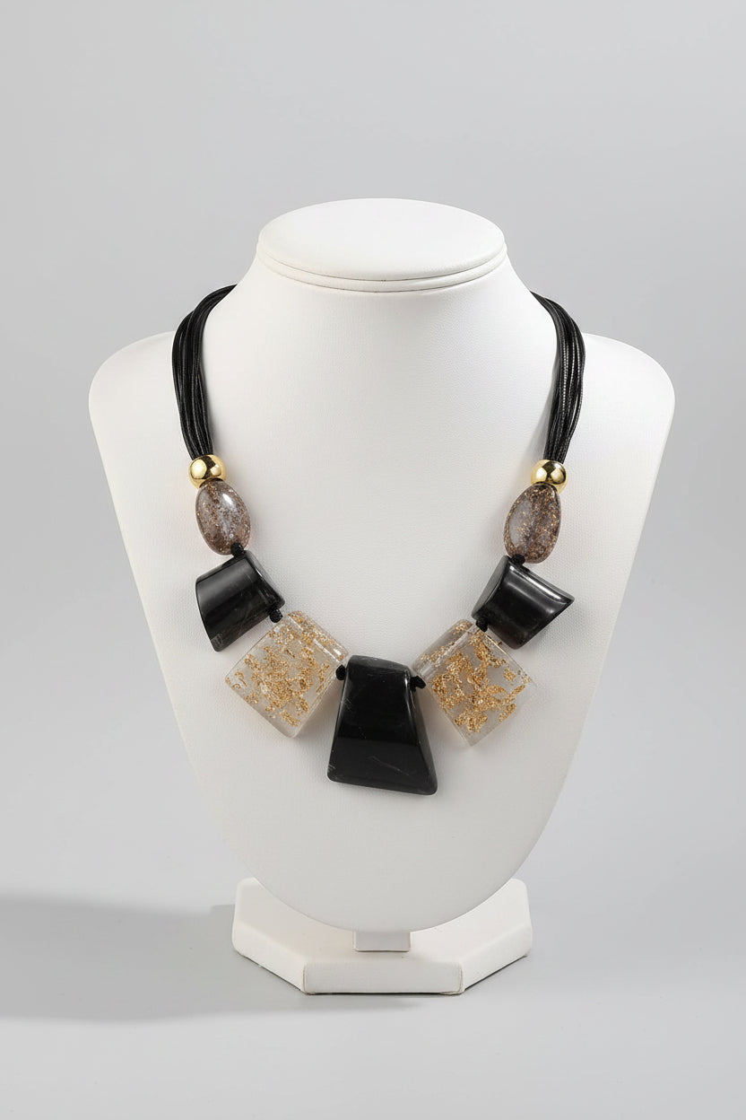 Necklace with black and gold beads on a mannequin