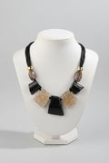 Necklace with black and gold beads on a mannequin