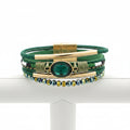 Multistrand bracelet with green and gold accents on a white background