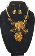 Gold circular necklace and earrings set on a black stand