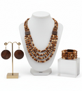 Wooden beaded necklace and earrings on a wooden surface with fall leaves.