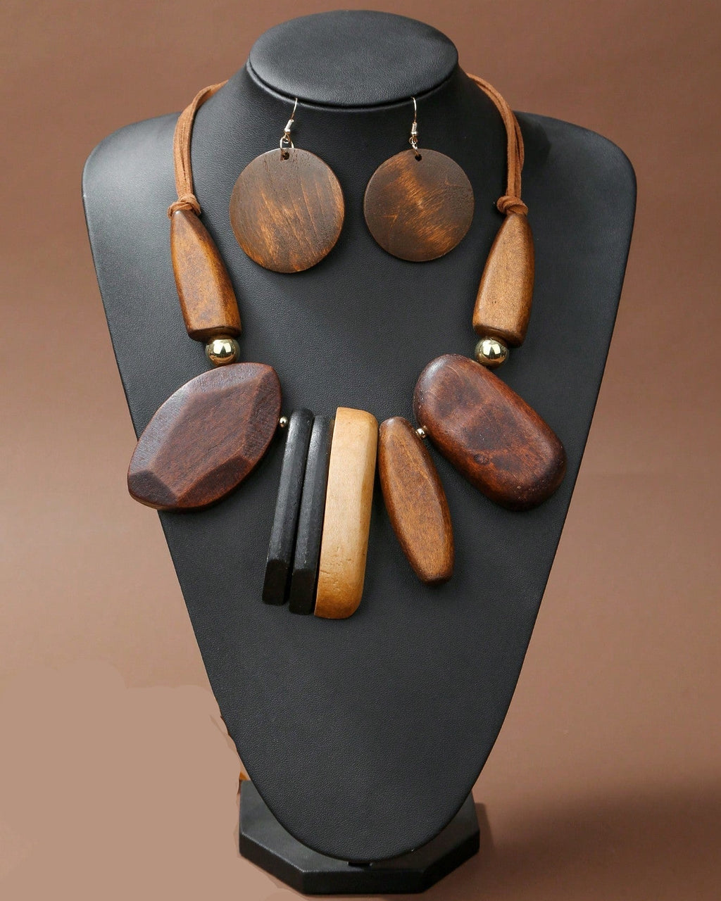Wooden jewelry set on a black mannequin bust against a brown background